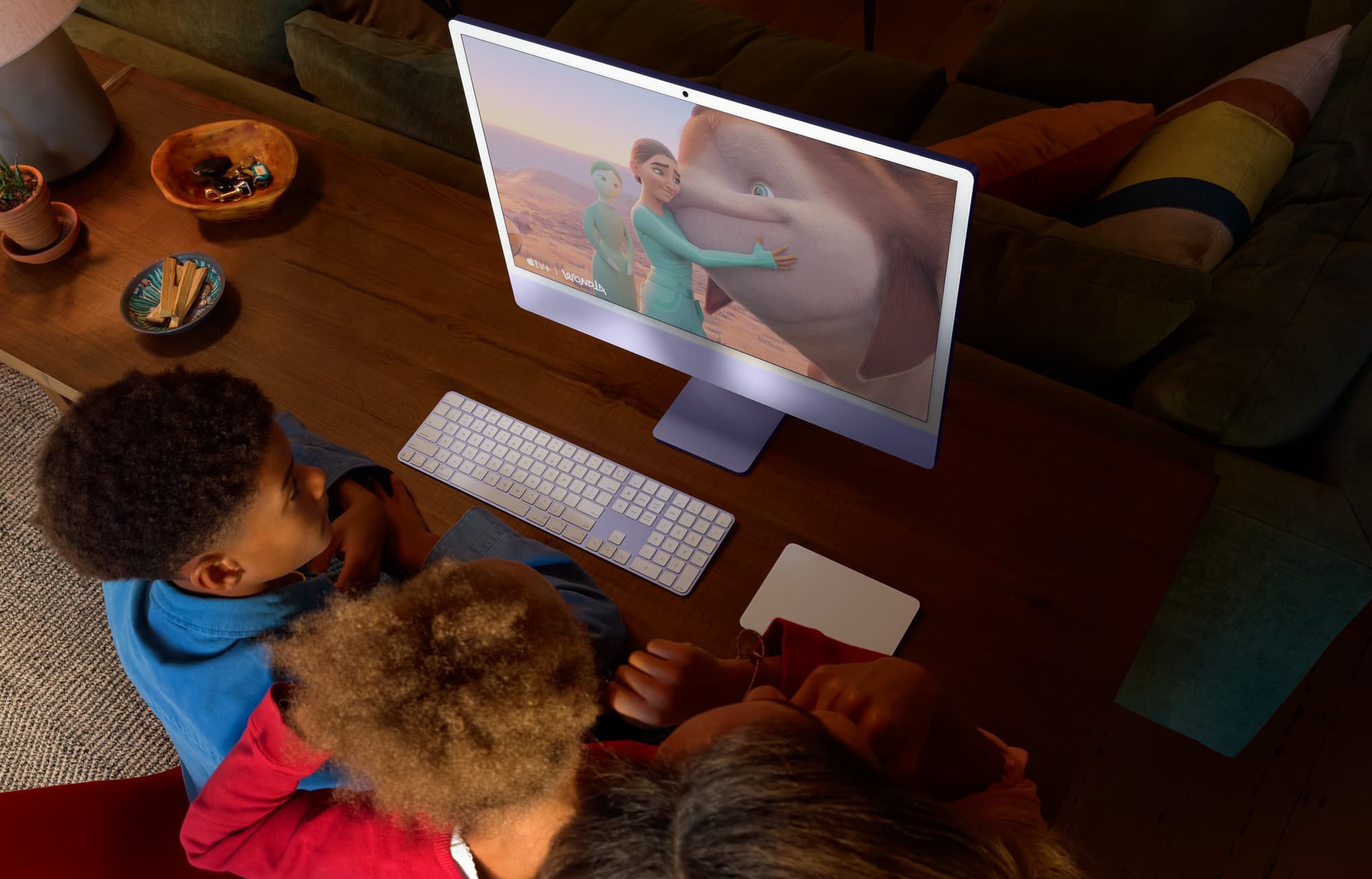 Familj som använder iMac vid köksbordet