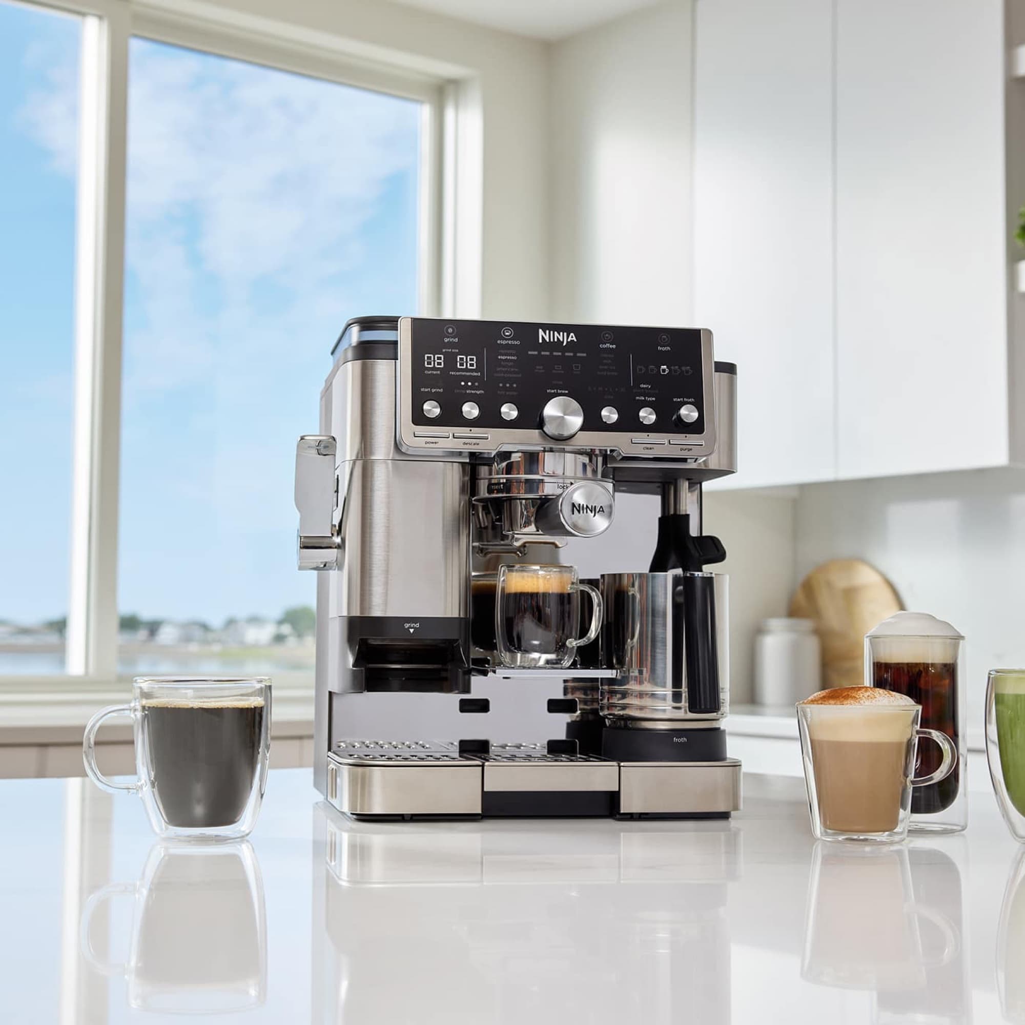 Maskinen i ett ljust kök med kaffedrycker