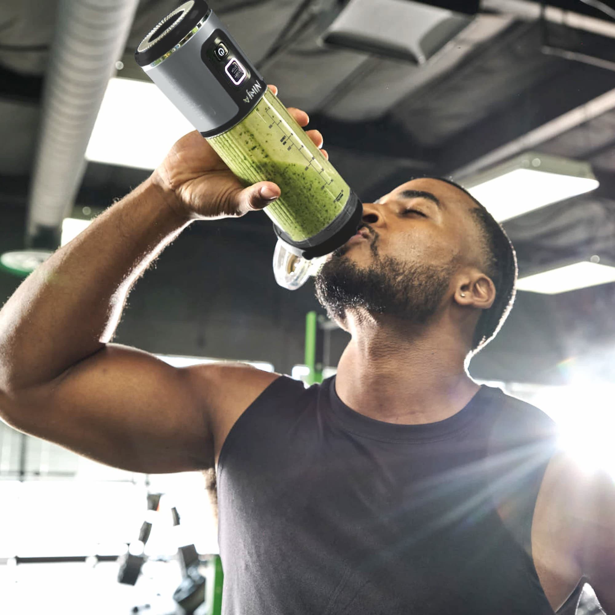 Man dricker direkt ur bägaren på gymmet