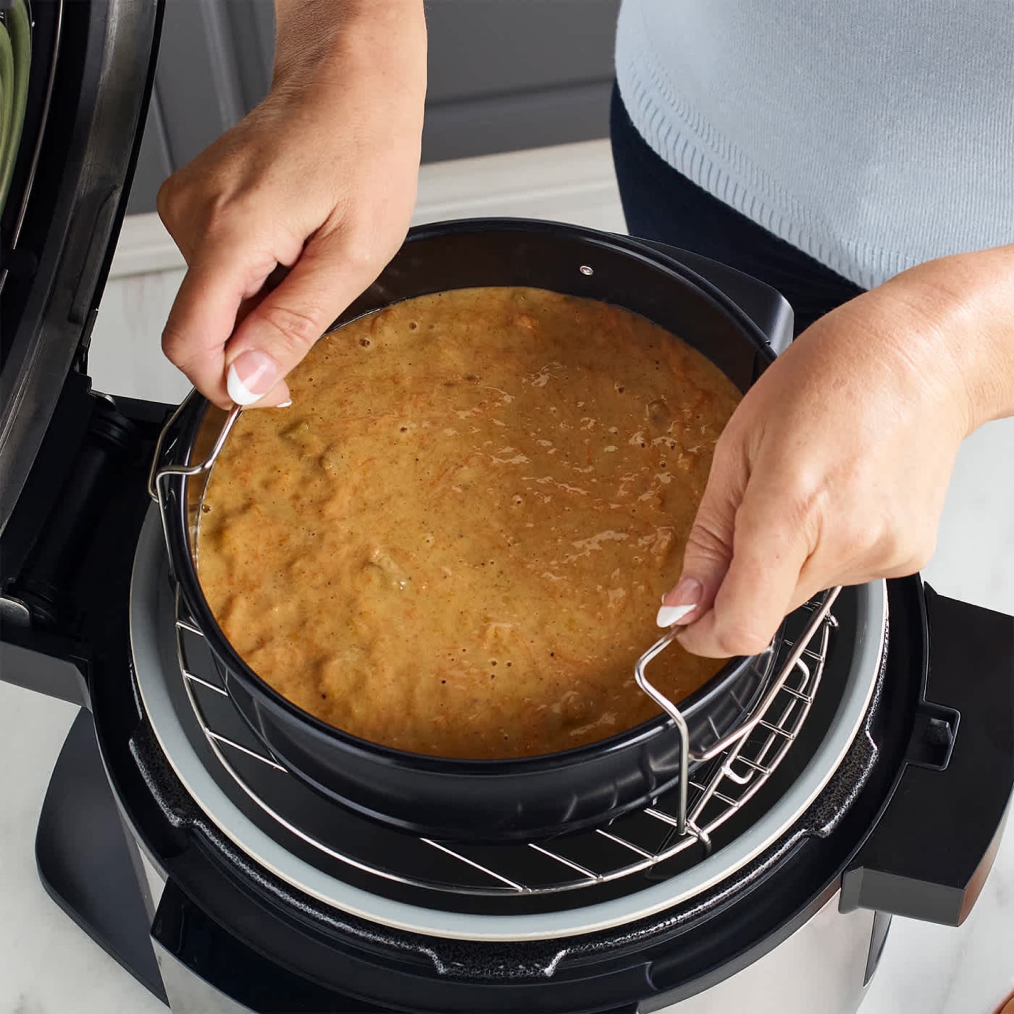 Cake in the round tin lifted out of the pot