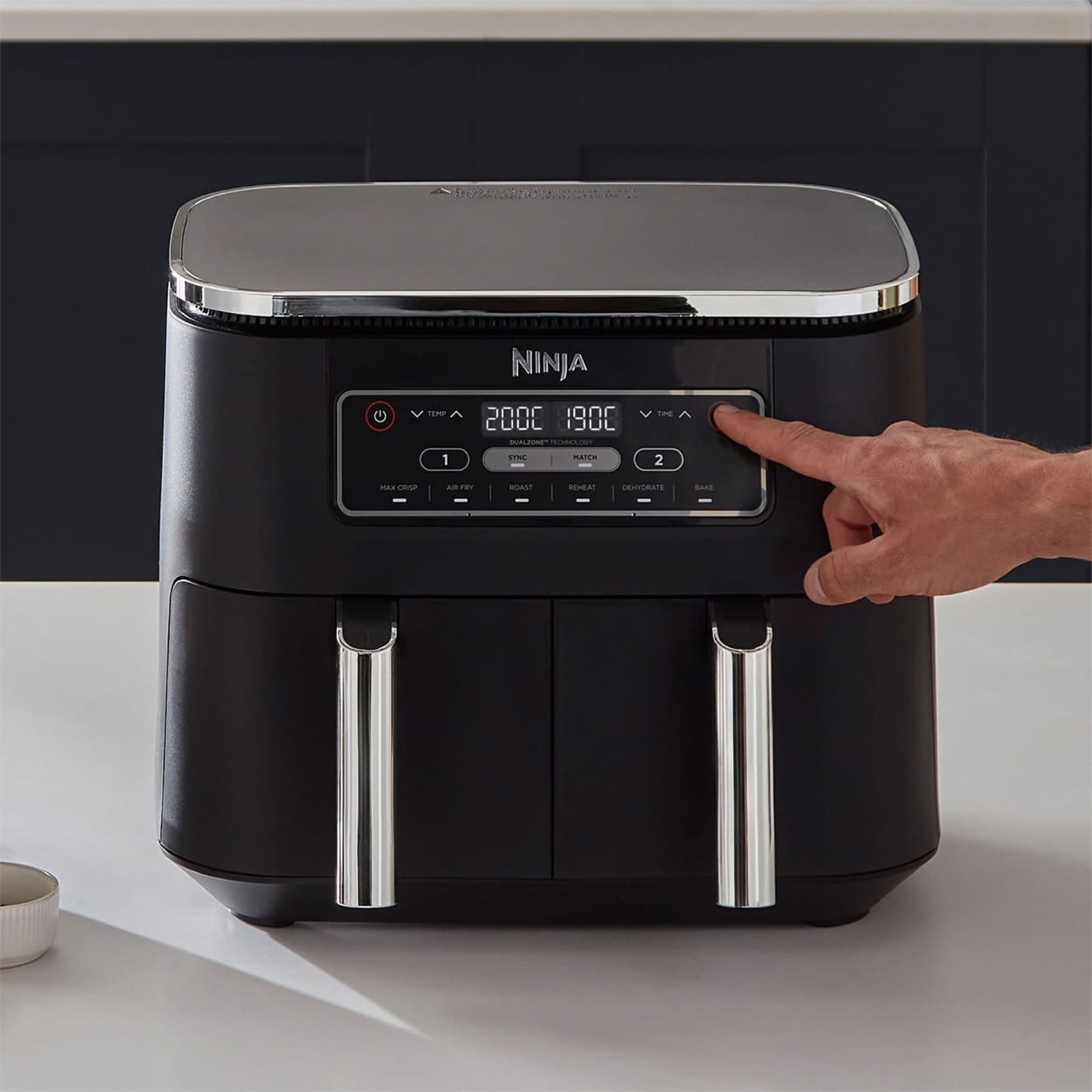 Finger setting the temperature on the control panel