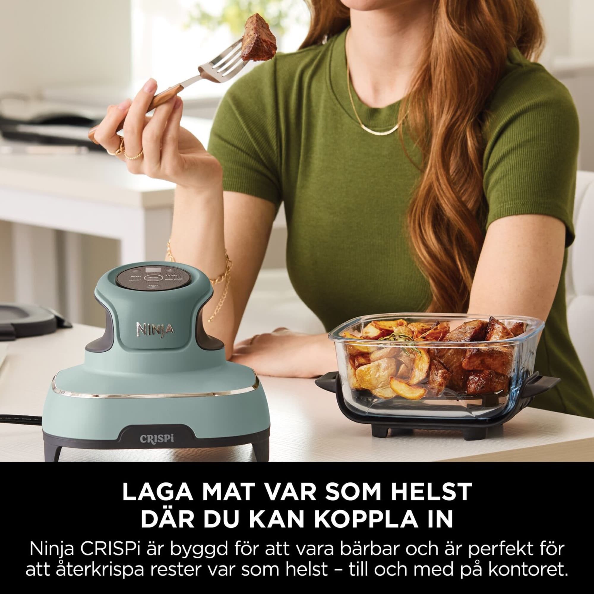 Kvinna äter lunch direkt ur glasformen vid skrivbordet
