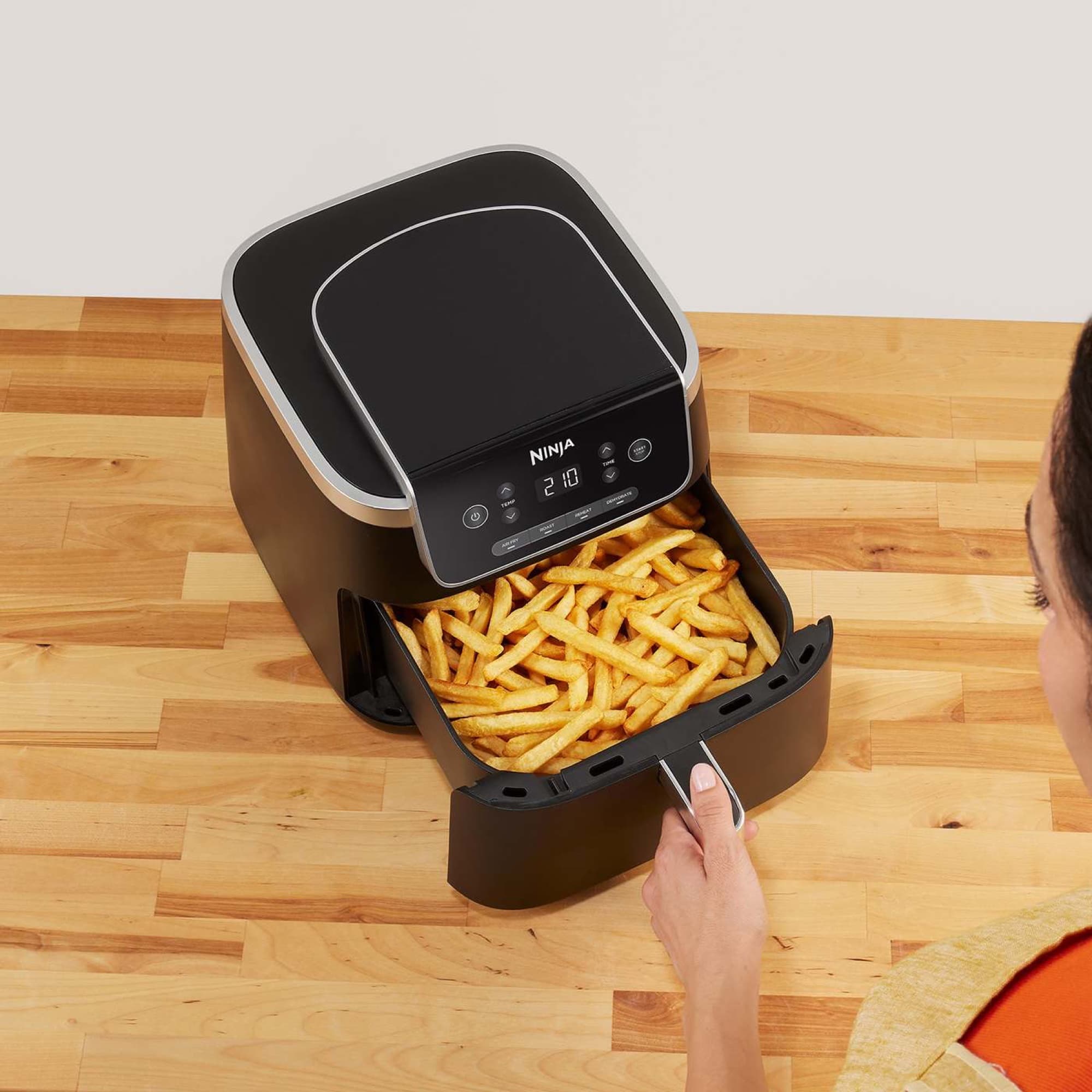 Hand som drar ut lådan full med pommes frites