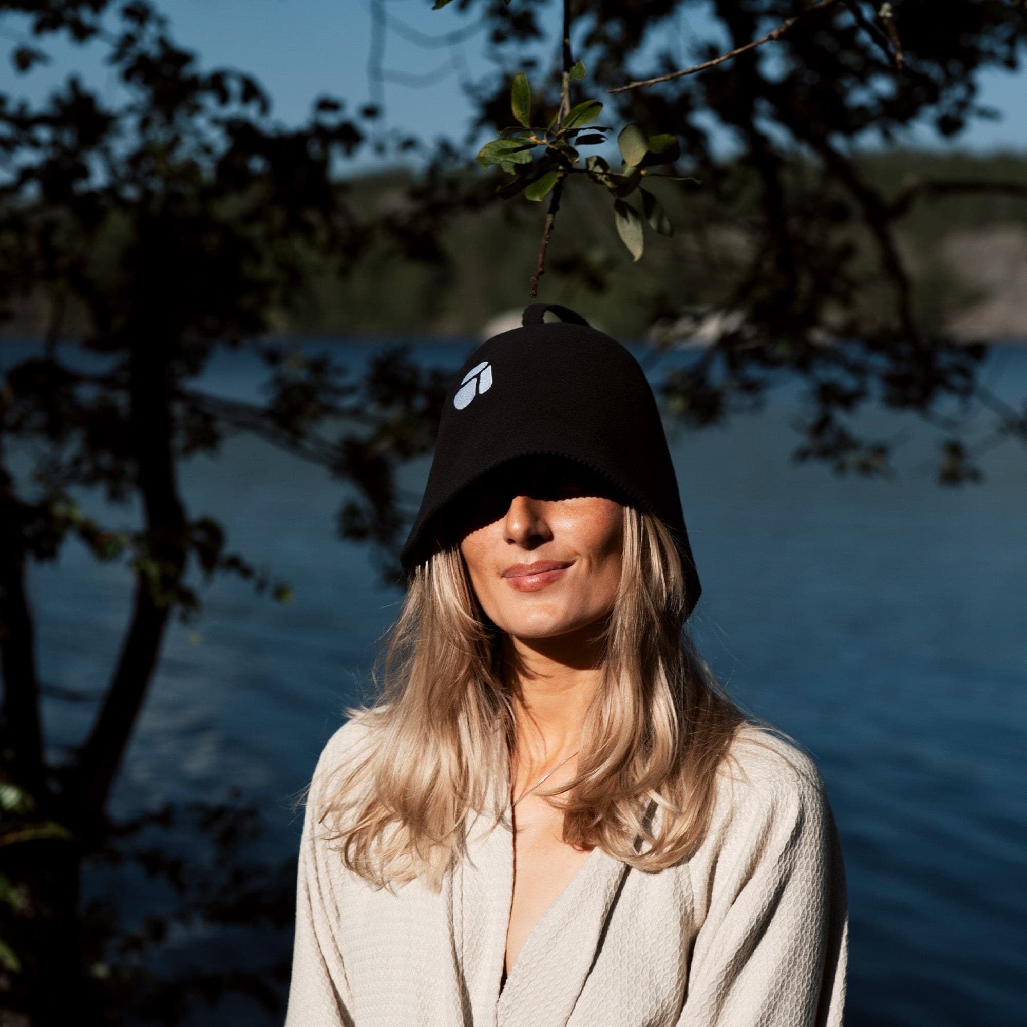 Kvinna i bastumössa vid vattnet